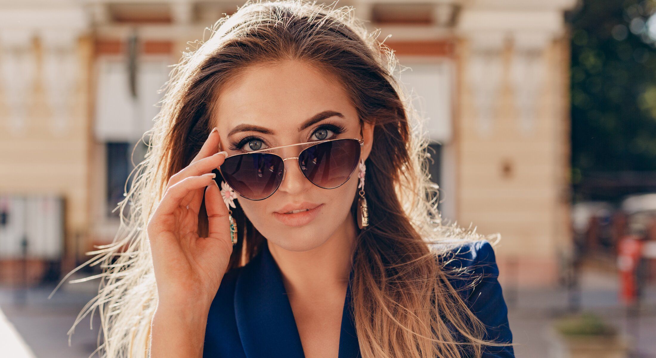 Woman wearing sunglasses and looking directly at camera.