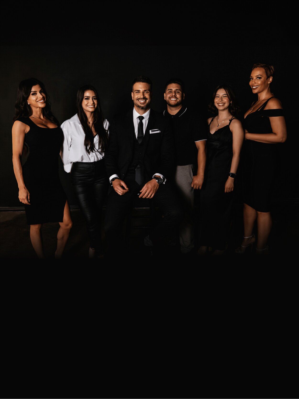 Group of six people posing together in formal attire.